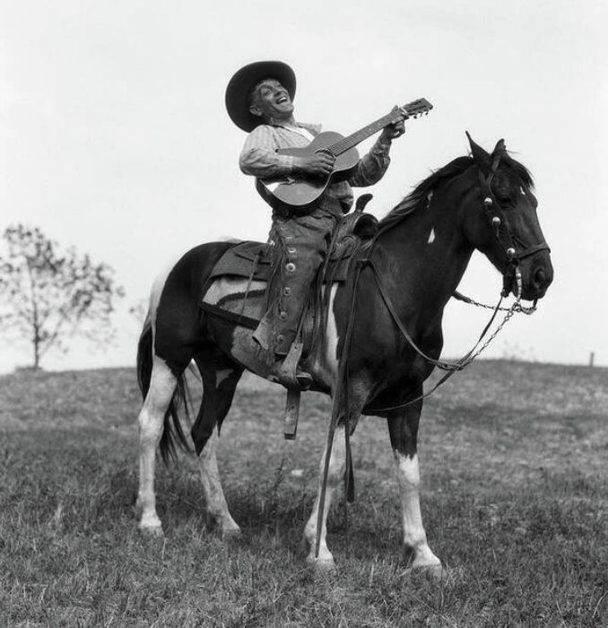 Cowboy On Horse Singing and Playing Guitar